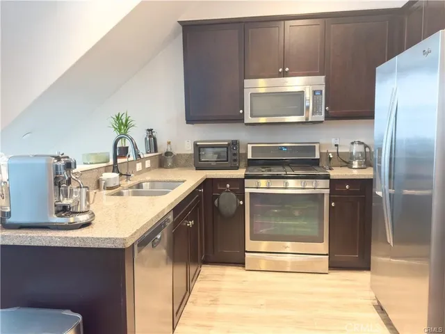 a kitchen with stainless steel appliances a stove a sink and a microwave