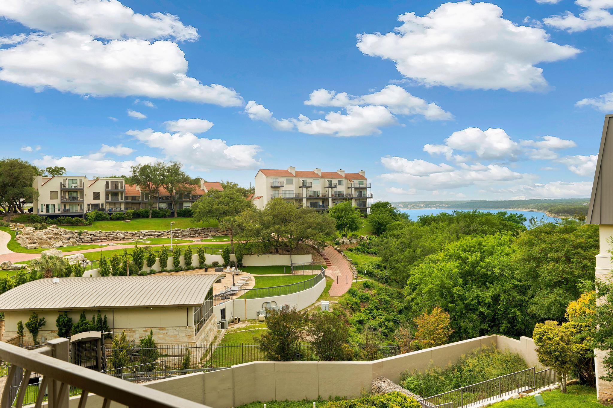 2918 Ranch Road 620, Unit J162 Austin, TX 78734 - Photo 2 of 26 Expansive outdoor environment featuring a view of Lake Travis , lush green trees, and terraced landscaping