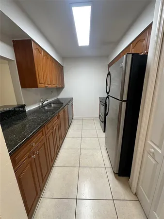 a kitchen with stainless steel appliances a refrigerator sink and cabinets