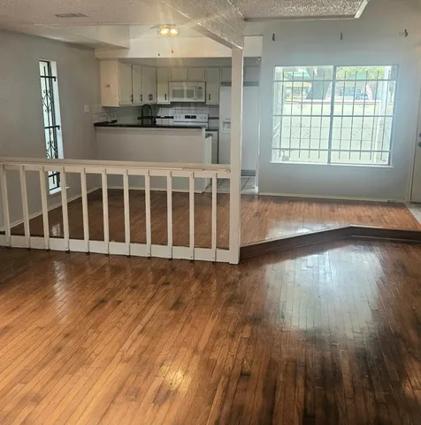 a view of a kitchen with wooden floor and a window