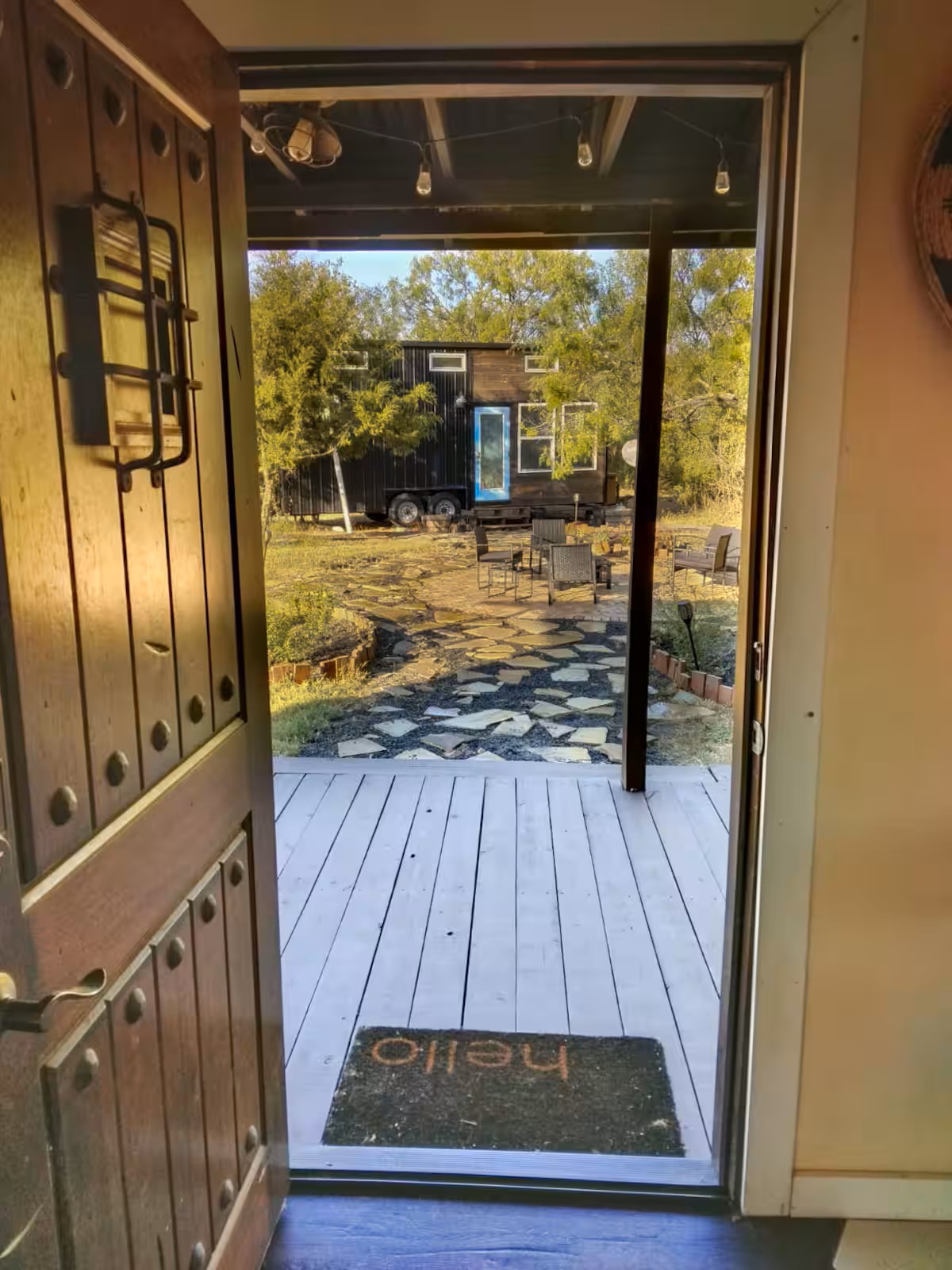 16107 Fagerquist Road Del Valle, TX 78617 - Photo 9 of 17 An inviting entry opens to a charming outdoor space with a tiny home and seating.