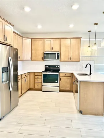 a kitchen with stainless steel appliances a stove sink and refrigerator