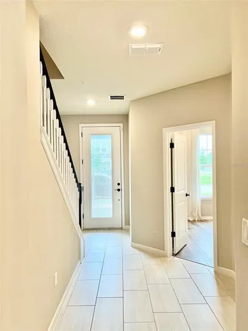 a view of a hallway with entryway and stairs