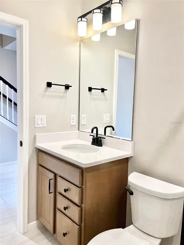 a bathroom with a sink a toilet a mirror and shower