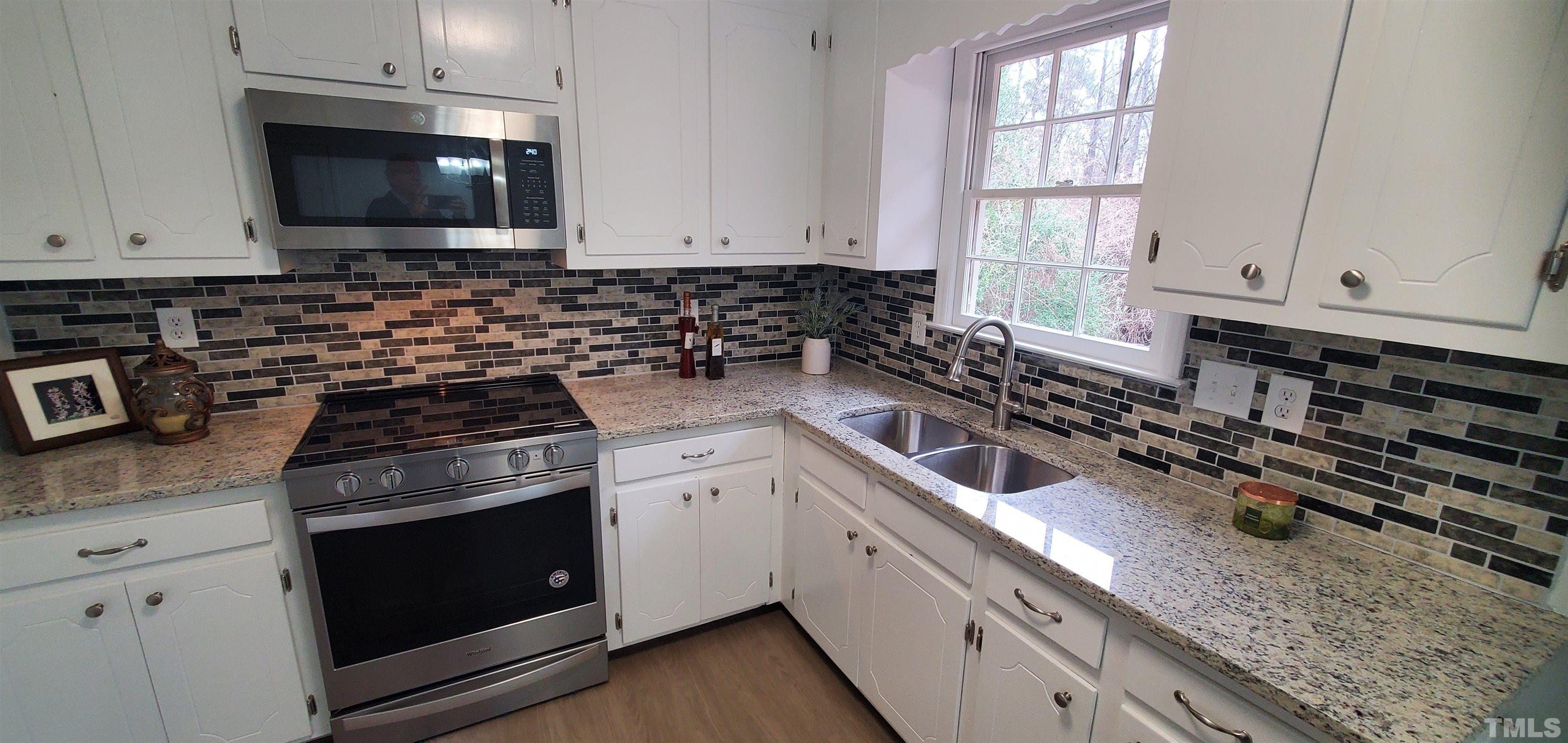 3817 Corwin Road Garner, NC 27529 - Photo 5 of 21 a kitchen with granite countertop a sink a stove and cabinets