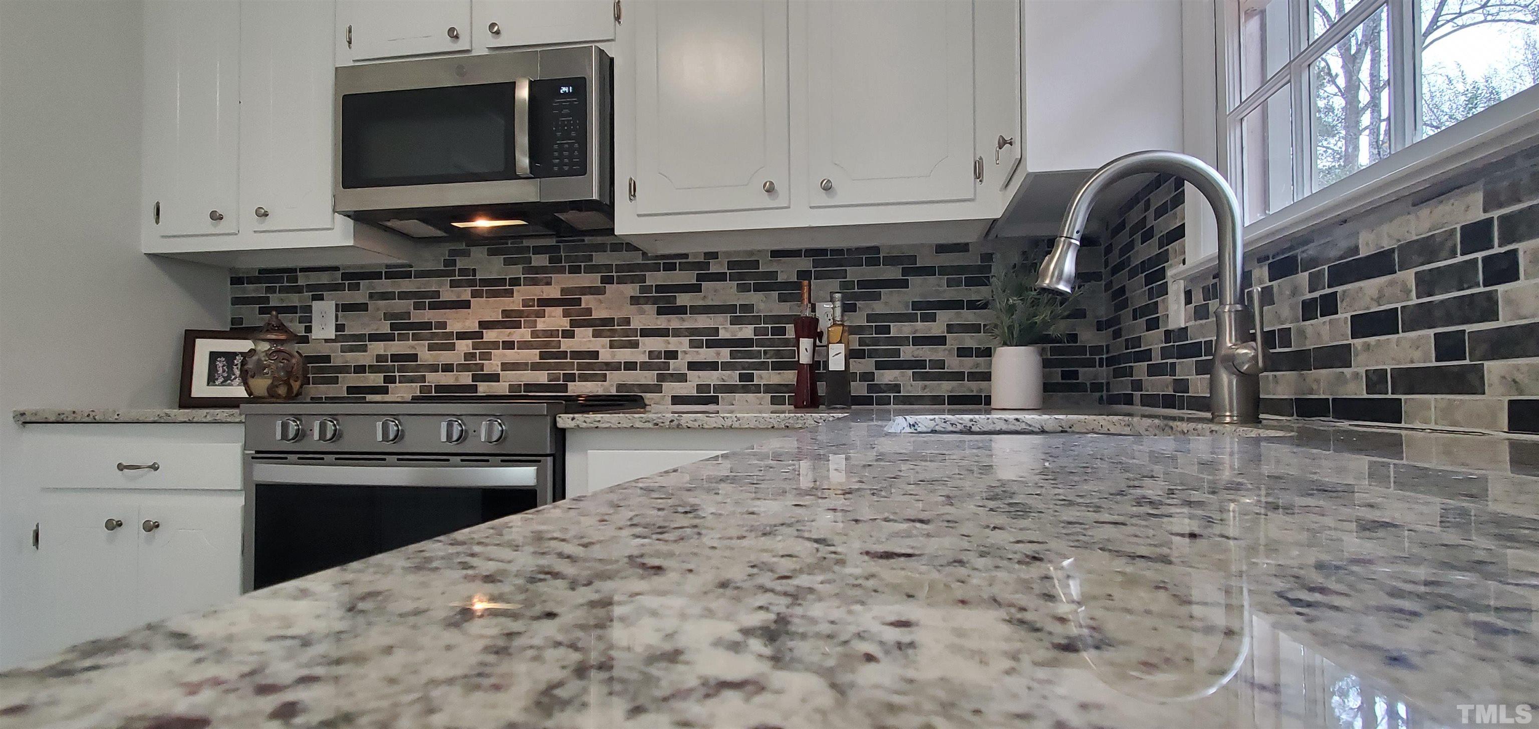 3817 Corwin Road Garner, NC 27529 - Photo 6 of 21 a kitchen with granite countertop a stove and a microwave