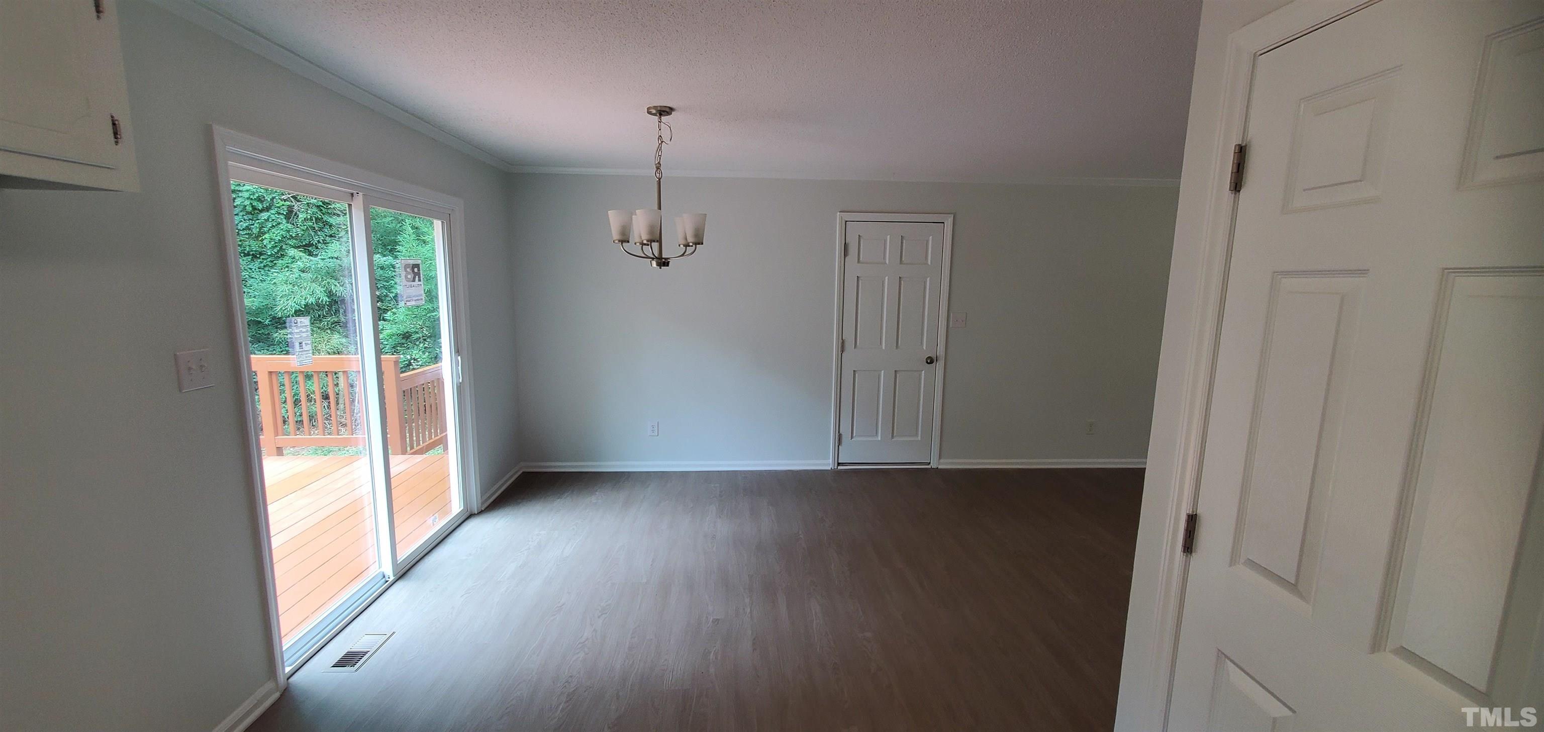 3817 Corwin Road Garner, NC 27529 - Photo 7 of 21 an empty room with wooden floor fan and windows
