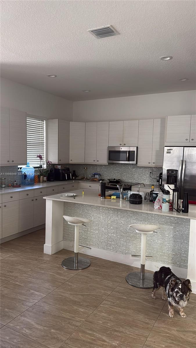 3564 West 97th Street Hialeah, FL 33018 - Photo 3 of 5 a kitchen with stainless steel appliances granite countertop a sink a stove a refrigerator a center island and cabinets