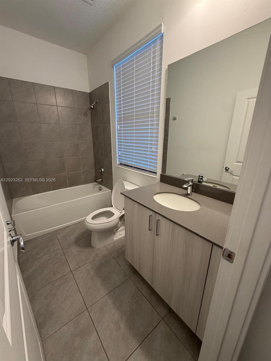 5669 Cerva Lane, Unit 5669 Immokalee, FL 34142 - Photo 13 of 32 a bathroom with a granite countertop sink toilet and shower