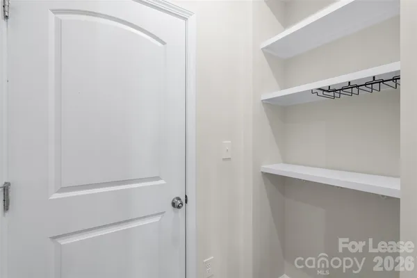a view of a hallway with wooden floor and closet