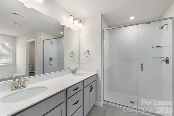a spacious bathroom with a granite countertop sink a mirror and a shower