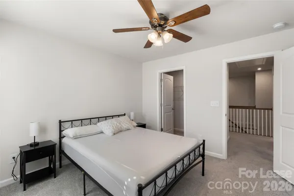 a view of a big room with windows and chandelier fan