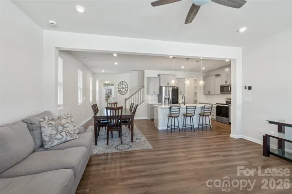 a living room with furniture and a dining table with kitchen view