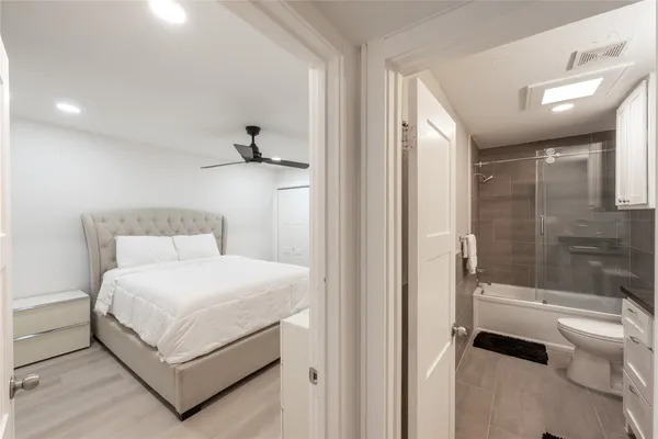 a bedroom with a bed and a glass door shower