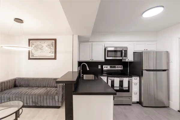 a living room with furniture and a refrigerator