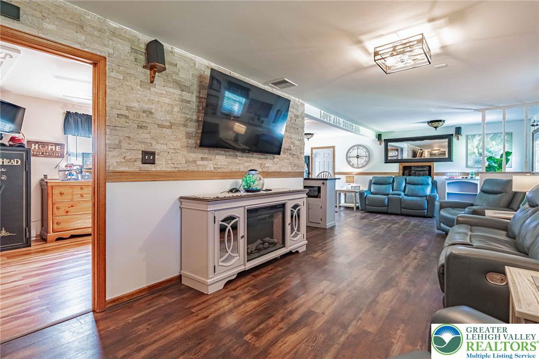 341 Lower Greenhill Road Kunkletown, PA 18058 - Photo 29 of 69 Rich hardwood floors flow through this welcoming living space, accented by a decorative stone wall.
