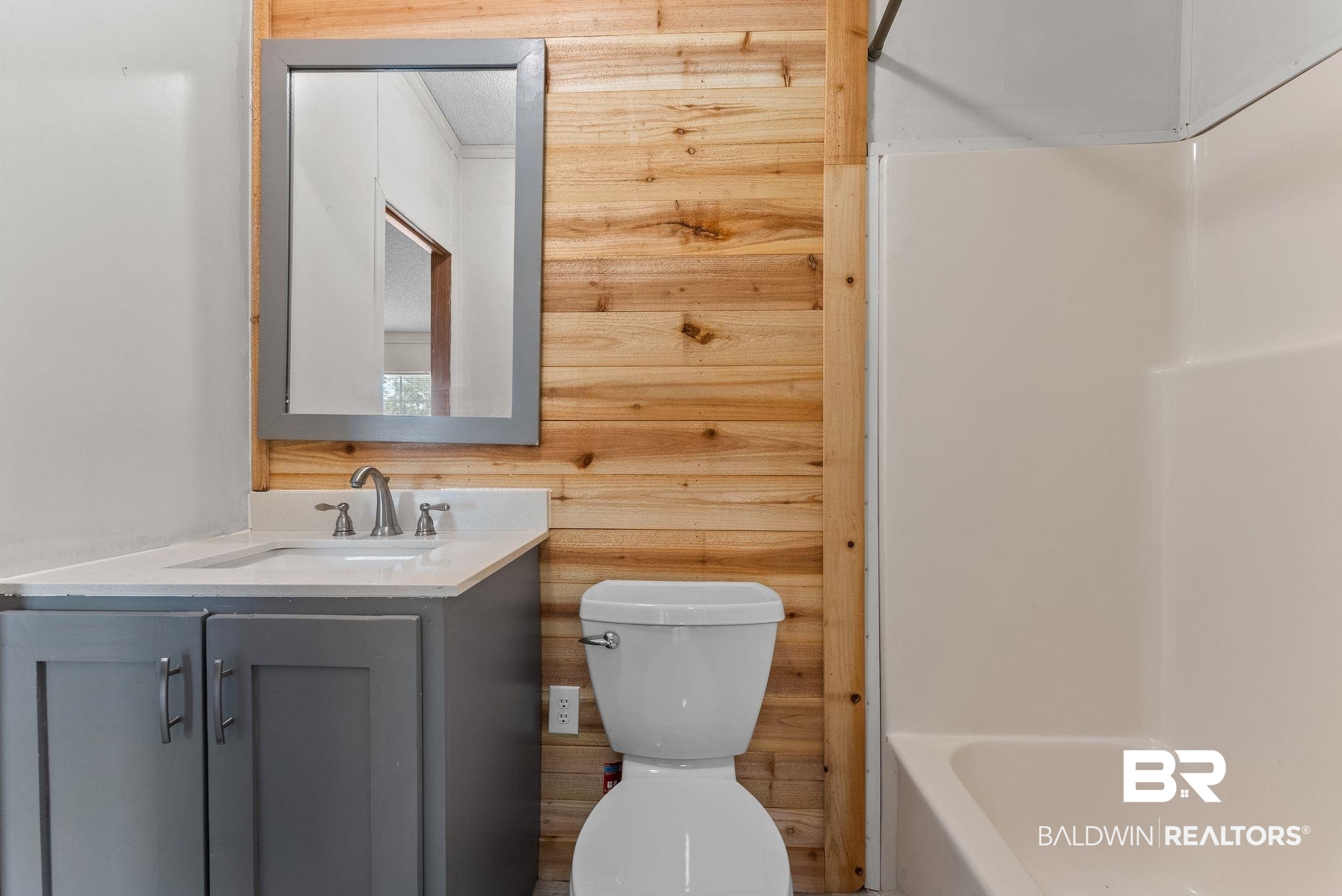 34904 Pine Road South Stapleton, AL 36578 - Photo 25 of 42 Full bathroom with vanity, wood walls, and bathing tub / shower combination