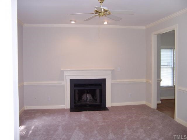 7229 Mine Shaft Road Raleigh, NC 27615 - Photo 2 of 6 a room with fireplace and a chandelier fan