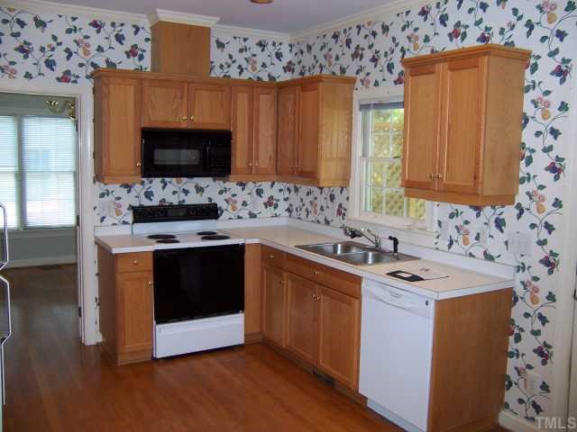 7229 Mine Shaft Road Raleigh, NC 27615 - Photo 4 of 6 a kitchen with stainless steel appliances wooden cabinets and a stove top oven