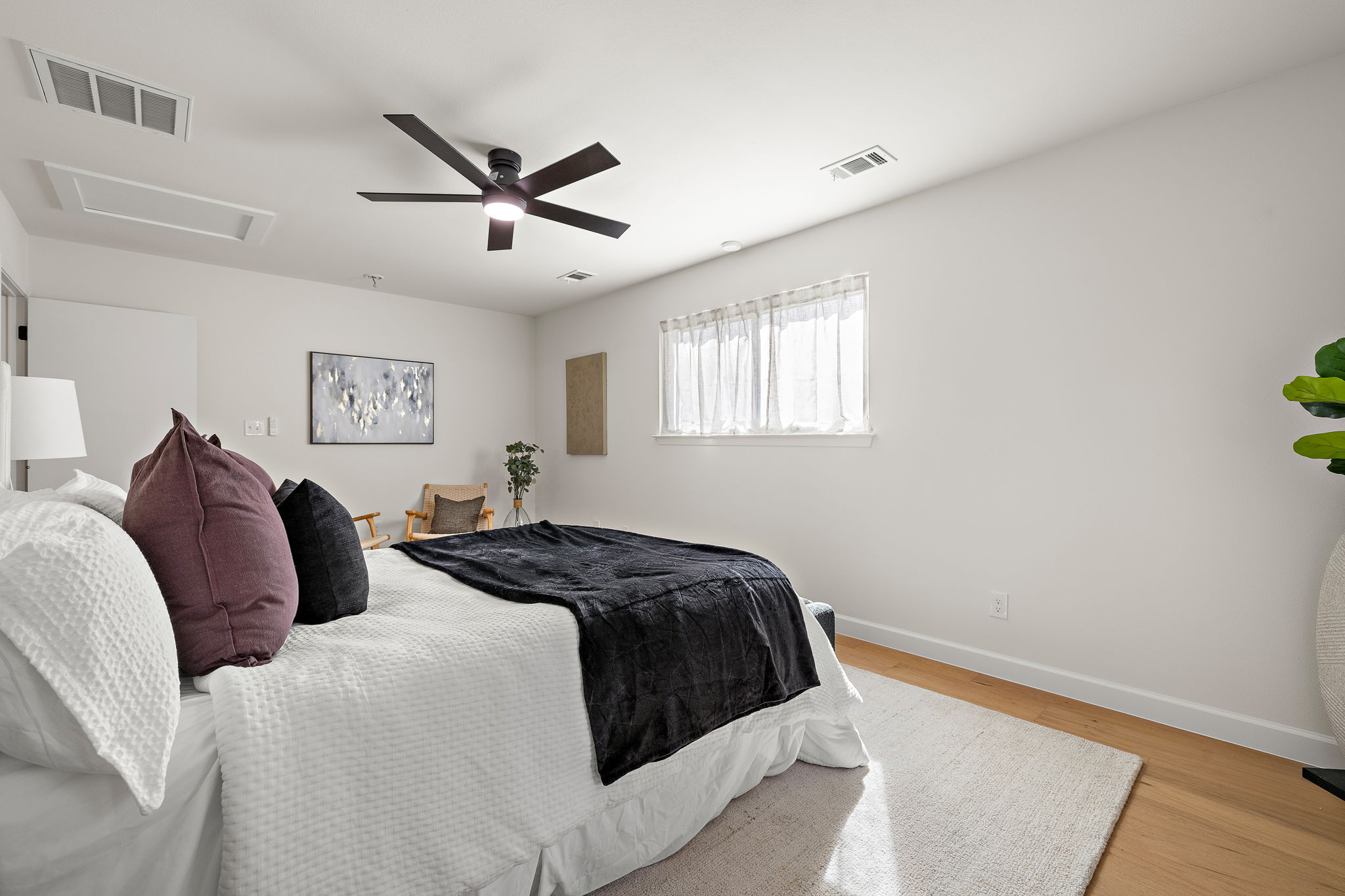8102 Burrell Drive Austin, TX 78757 - Photo 19 of 35 a bedroom with a large bed and a ceiling fan
