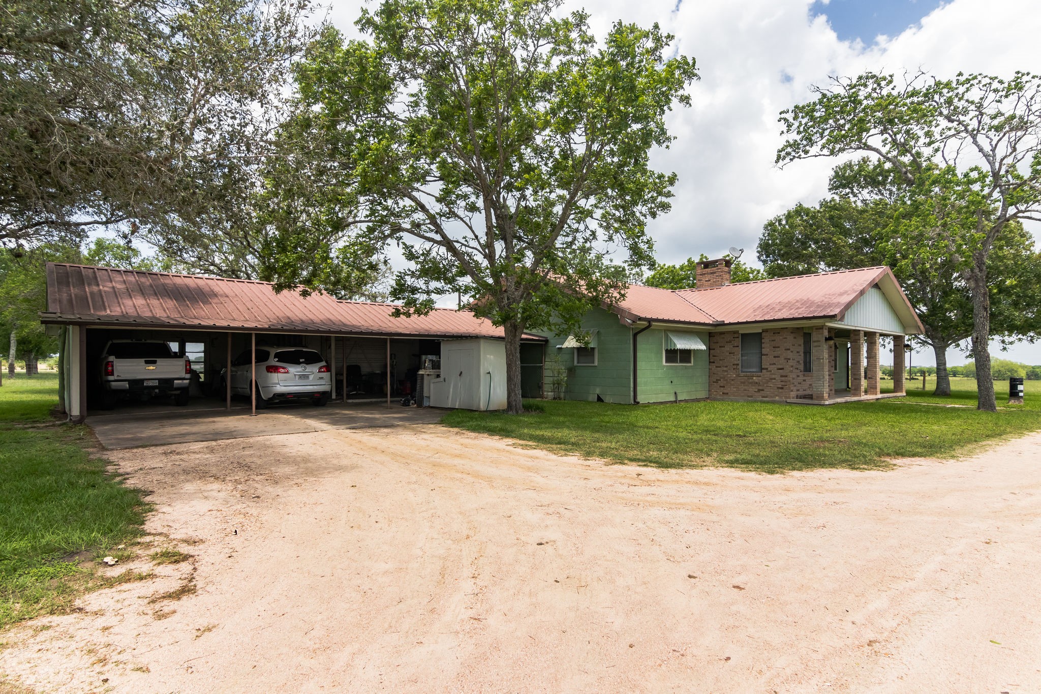 1230 FM 155 Weimar, TX 78962 - Photo 18 of 27 a front view of a house with a garden and trees