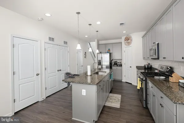 a kitchen with stainless steel appliances granite countertop a sink stove and refrigerator