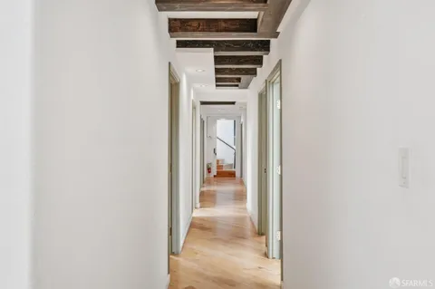 a view of a hallway with wooden floor and entryway