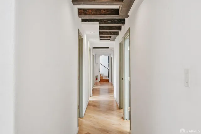 a view of a hallway with wooden floor and entryway