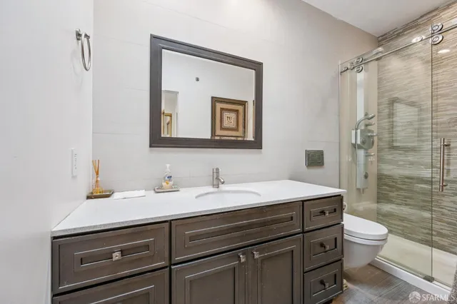 a bathroom with a sink a toilet and shower