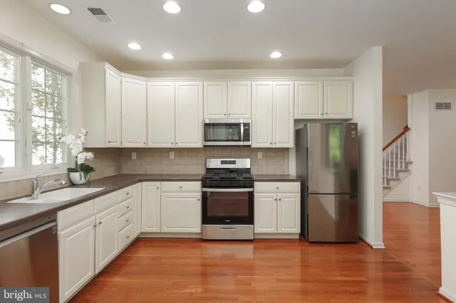a kitchen with a refrigerator sink and wooden floor