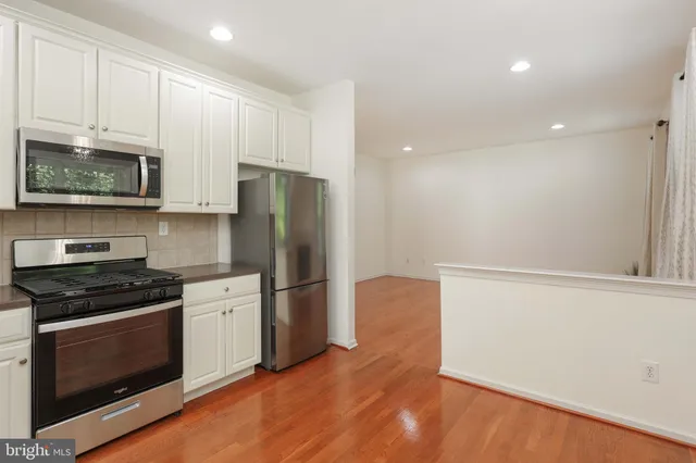 a kitchen with granite countertop a refrigerator stove and microwave