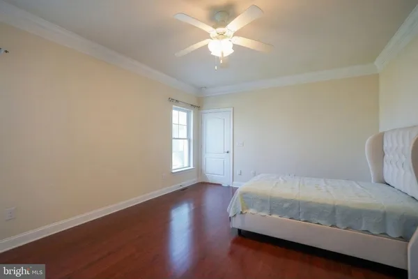 an empty room with a chandelier fan and windows