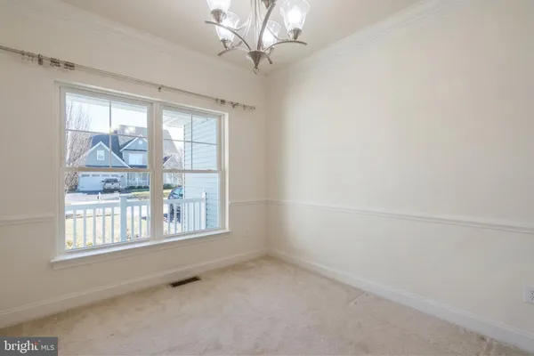 a view of a livingroom with a chandelier fan and windows