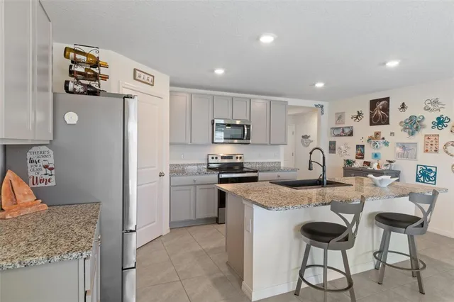 a kitchen with stainless steel appliances granite countertop a refrigerator and a stove top oven