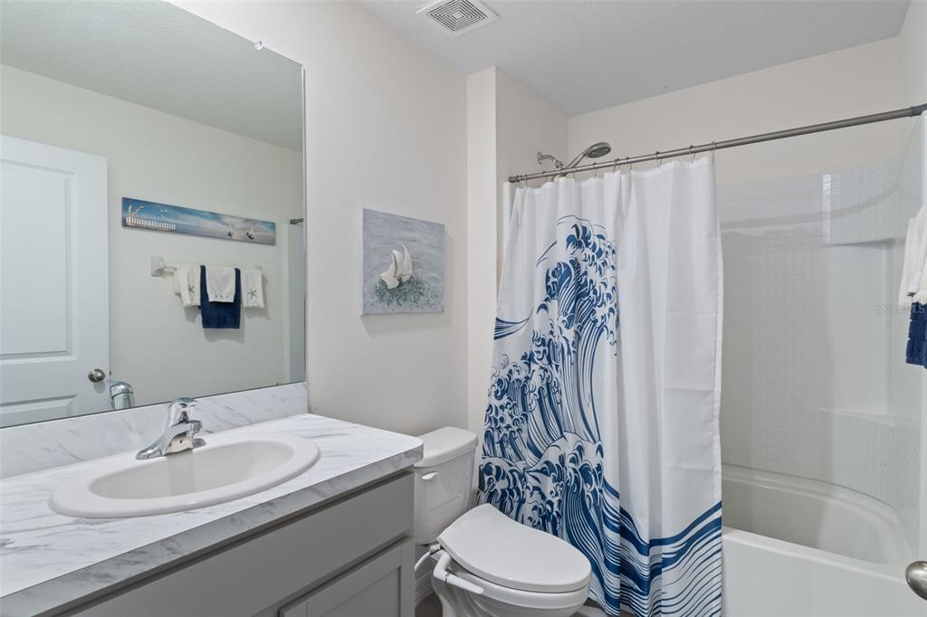 7514 Gardner Street Brooksville, FL 34613 - Photo 31 of 49 a bathroom with a sink a toilet and shower curtain