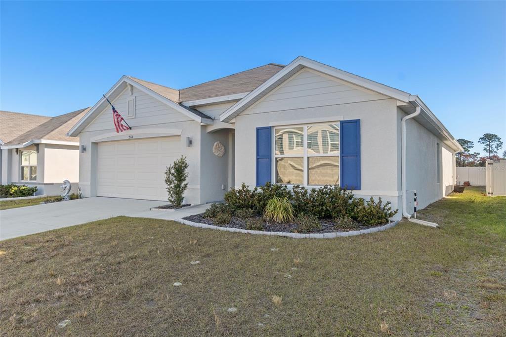 7514 Gardner Street Brooksville, FL 34613 - Photo 4 of 49 a front view of a house with garden