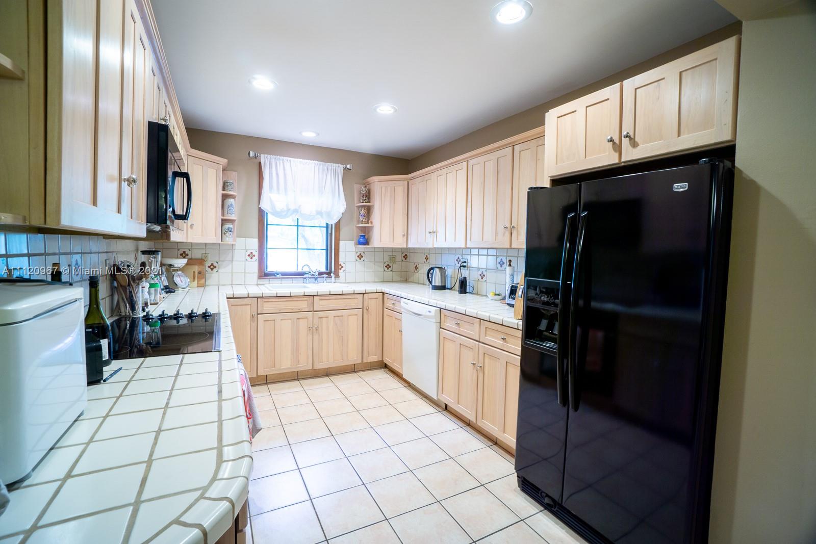 4423 Anderson Road Coral Gables, FL 33146 - Photo 6 of 18 a kitchen with stainless steel appliances granite countertop a refrigerator sink and cabinets