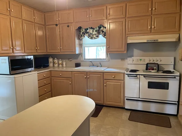 a kitchen with a sink a stove and cabinets