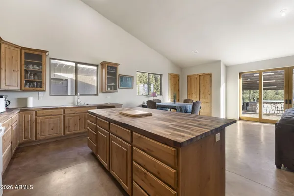 a living room with kitchen and a wooden floor