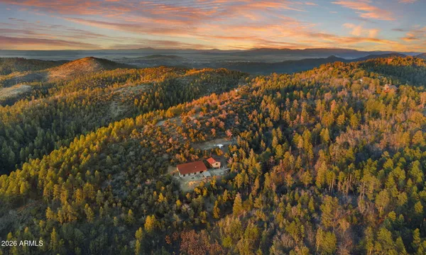 an aerial view of a house with a yard and mountain view in back