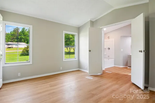 an empty room with windows and closet