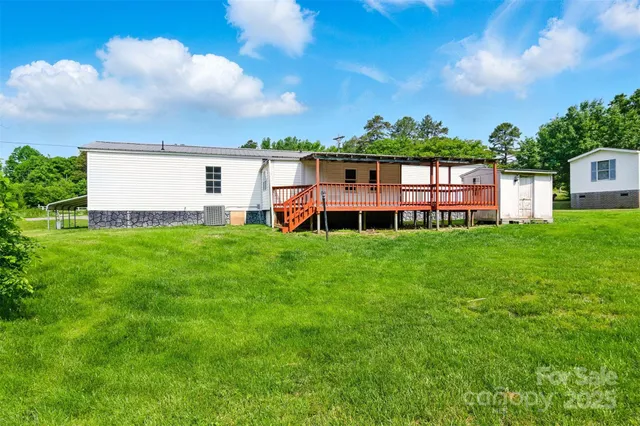 a view of a house with a yard and a large tree
