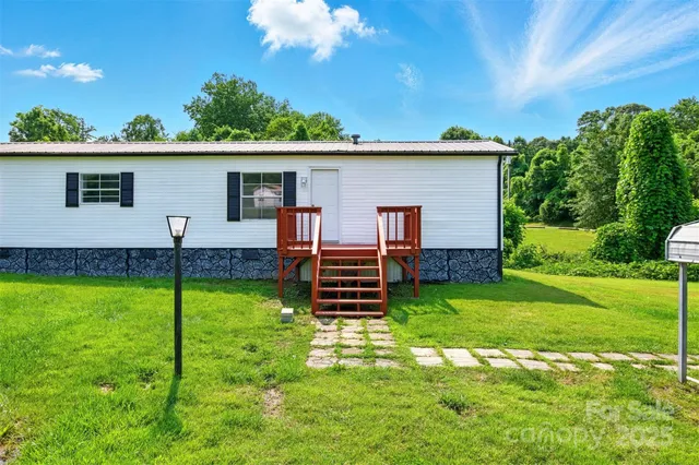 a backyard of a house with plants and wooden fence