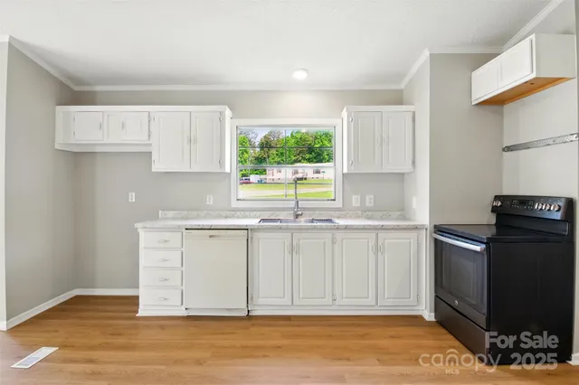 a kitchen with granite countertop a stove a sink and a window