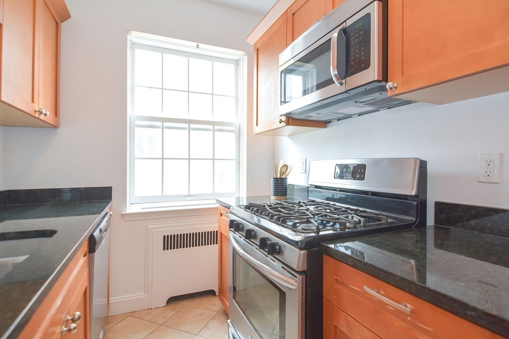 40 Browne Street, Unit 5 Brookline, MA 02446 - Photo 16 of 39 a kitchen with stainless steel appliances granite countertop a stove and a microwave