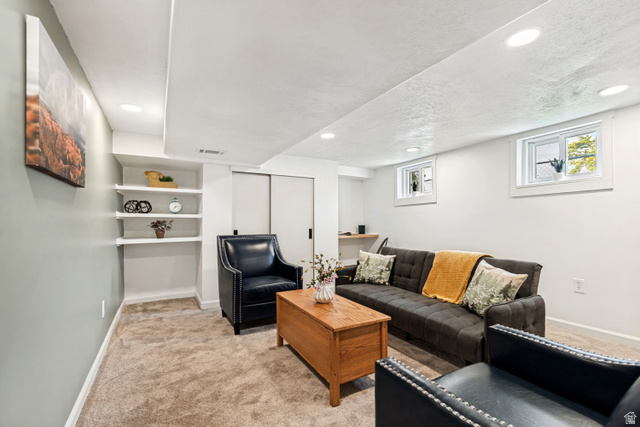 4883 South Center Street Murray, UT 84107 - Photo 20 of 32 Recessed lighting illuminates this versatile living space, featuring neutral carpeting and built-in shelving