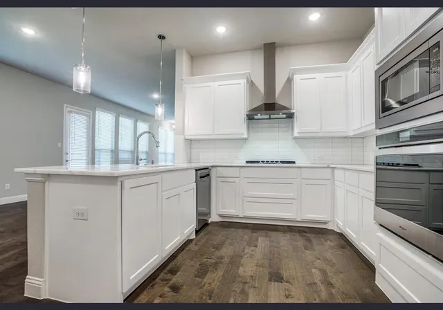 a kitchen with stainless steel appliances granite countertop a stove and white cabinets
