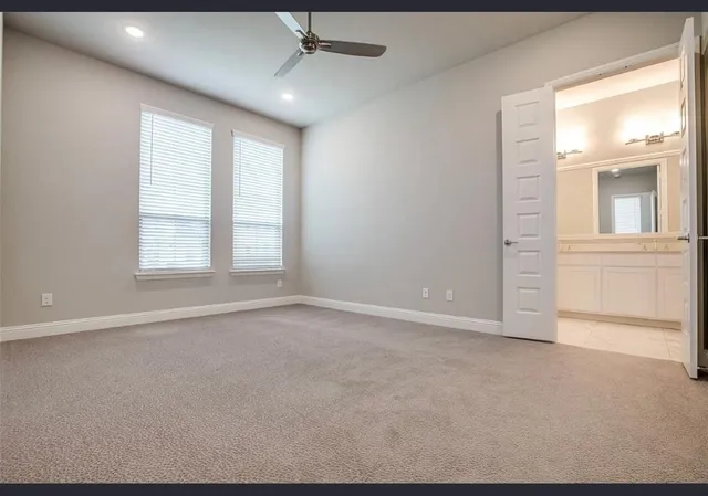 en empty room with windows and chandelier fan