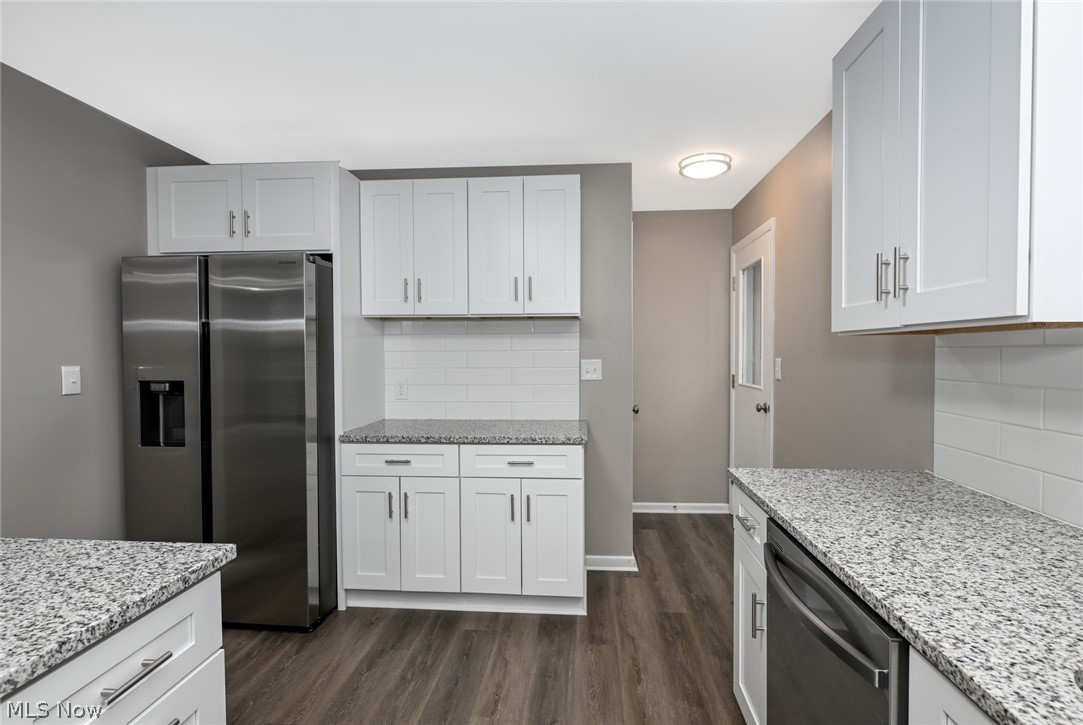 773 Bishop Road Cleveland, OH 44143 - Photo 10 of 34 Kitchen with backsplash, stainless steel appliances, white cabinets, and dark wood-type flooring