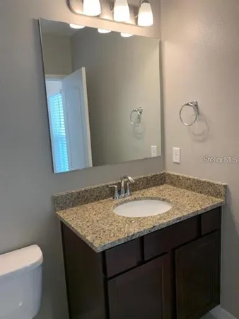 a bathroom with a granite countertop sink and a mirror
